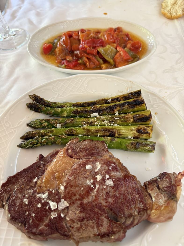 Chuletón a la brasa de ternera con espárragos trigueros y pimientos asados.